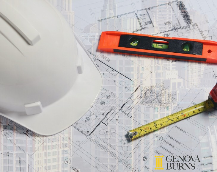 Hard hat, level and measuring tape on building plans